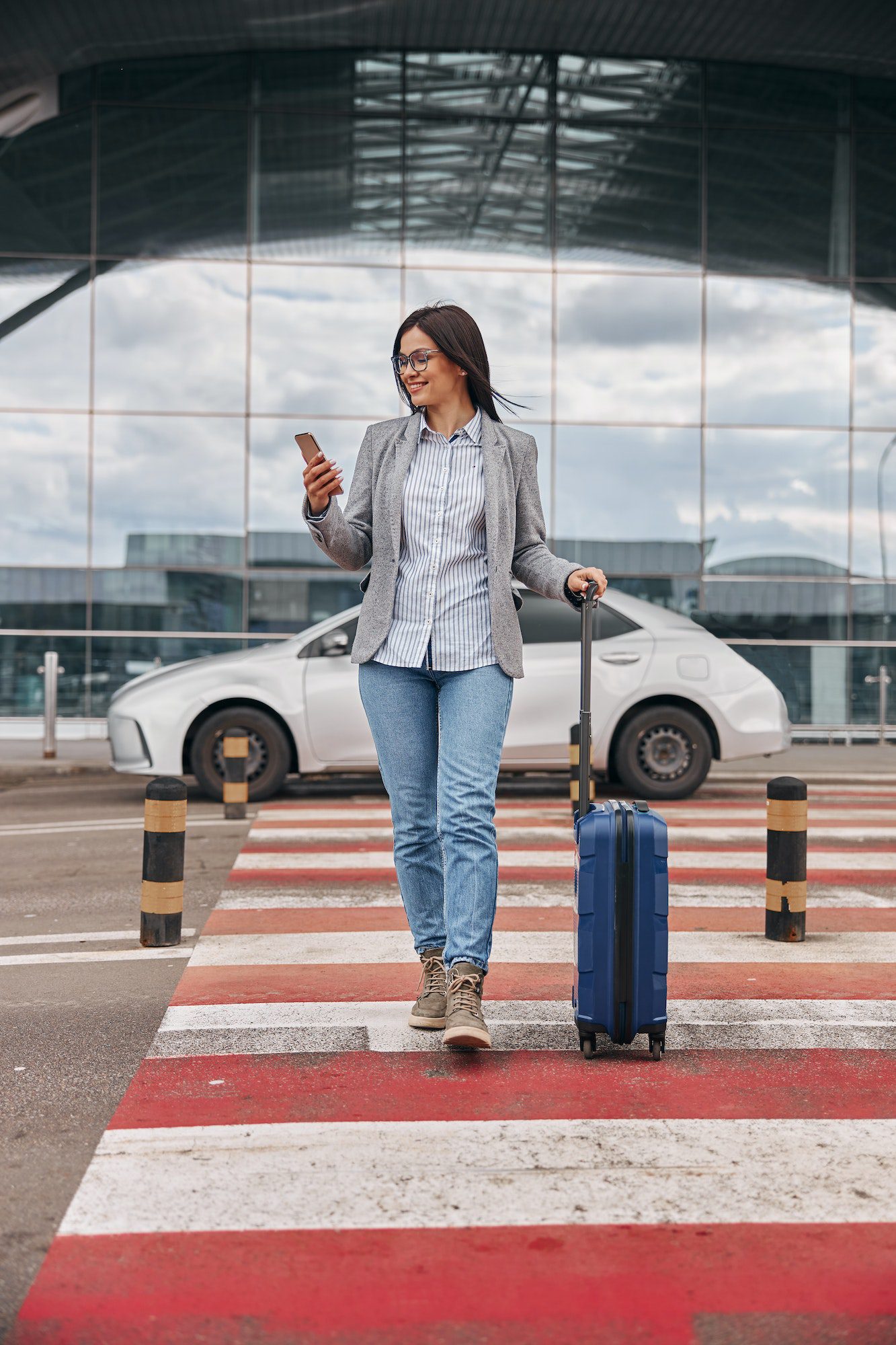 Happy caucasian woman traveller in Buffalo airport parking terminal with luggage